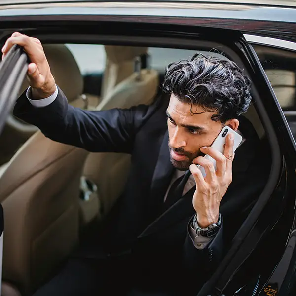 Homme d'affaire au téléphone sortant d'une voiture